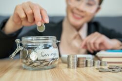 woman puting a coin in her savings